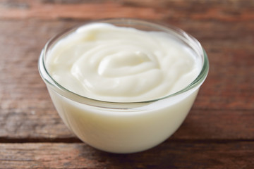 Yogurt in glass bowl on wooden table