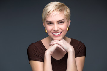 Naklejka premium Blonde short pixie haircut portrait fun charming smile perfect teeth confident business woman professional