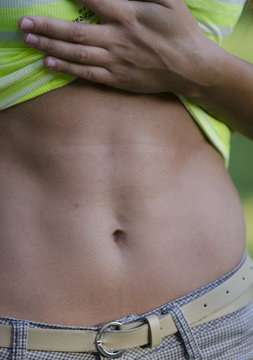 A woman showing her abdomen, close up.