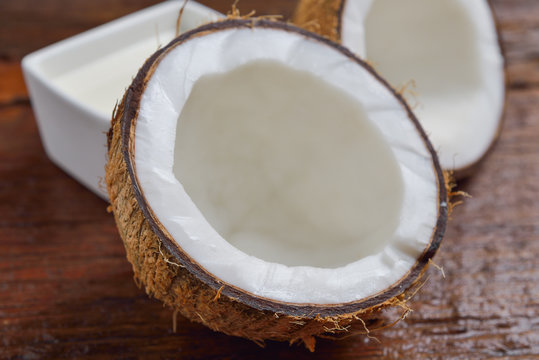 Coconut and coconut milk in square white bowl on wooden table