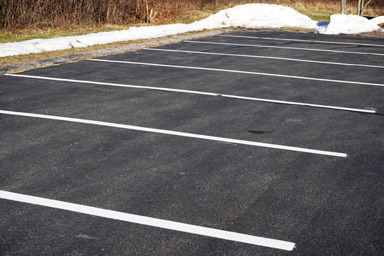 empty parking lot in winter with snow piles outside