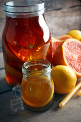 Iced tea with lemon and grapefruit on wooden background