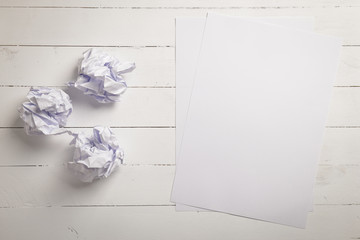 White paper and Crumpled paper balls on white color wood plank b