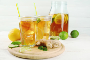 Iced tea with lemon on light wooden background