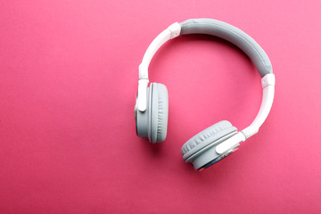 Wireless white and grey headphones on pink background