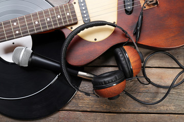Naklejka na ściany i meble Electric guitar and headphones with microphone and vinyl on wooden background