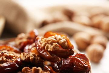 Walnut and date fruit on wooden table, close-up