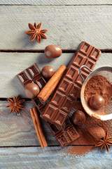 Chocolate sweets with powder on wooden background