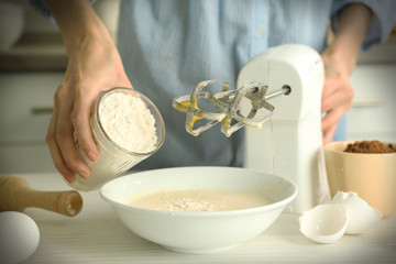 Woman is adding flour to the mixture