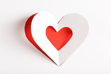 Cut out white paper heart on red background