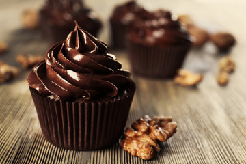 Chocolate cupcakes with nuts on wooden table
