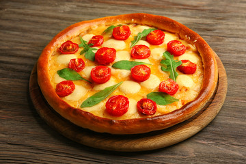 Pizza Margherita with arugula on wooden background