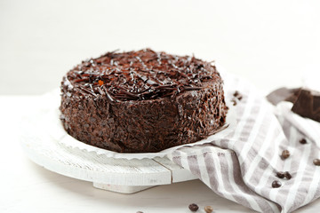 Tasty chocolate cake on wooden table, on light background