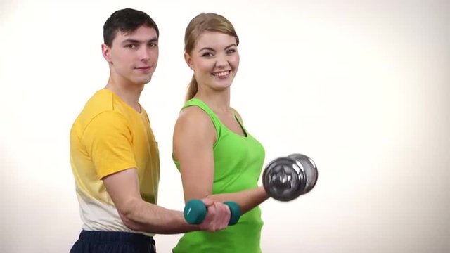 Couple exercising with dumbbells lifting weights 4K
