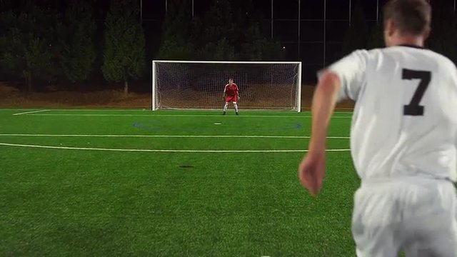 The camera follows a soccer player down the field as shoots and misses a goal