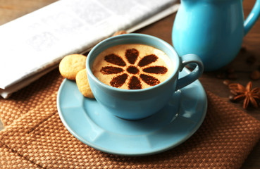 Cup of coffee  and fresh newspaper on wooden table background