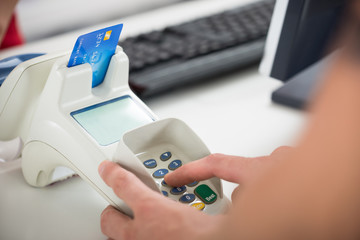 Customer's Hand Entering Pin Code On Card Reader