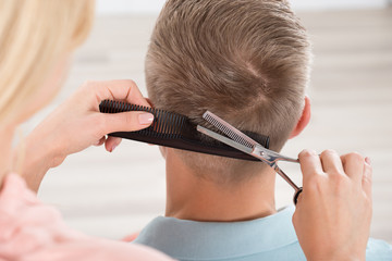 Obrazy na Szkle  Mężczyzna dostaje fryzurę od kobiecego fryzjera w salonie