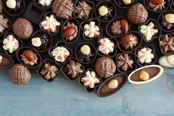 Assorted chocolate candies on wooden background, close up