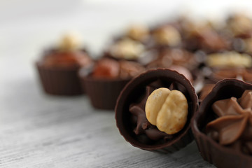 Delicious chocolate candies on wooden  table, close up
