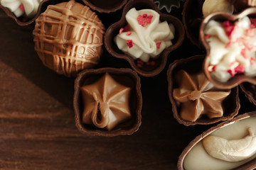 Delicious chocolate candies on wooden background, close up