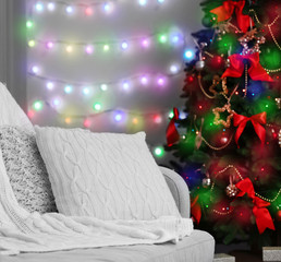 Decorated Christmas tree beside sofa