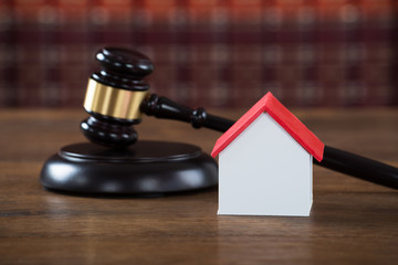 Mallet With House Model On Table In Courtroom