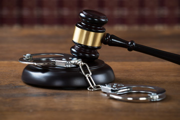 Mallet And Handcuffs On Table In Courtroom