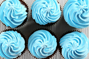 Delicious cupcakes on white wooden background, close up