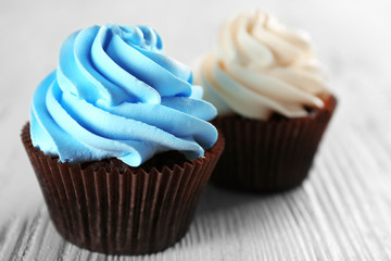 Fresh delicious cupcakes in a row on white wooden  background