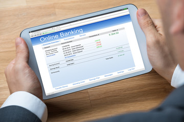 Businessman Doing Online Banking On Digital Tablet