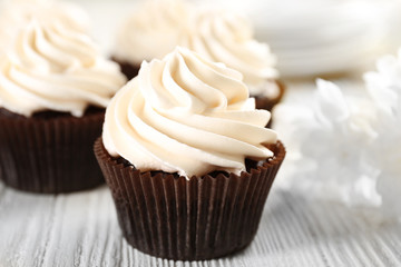 White cupcakes on wooden table