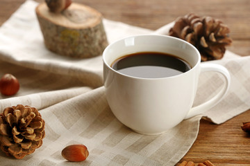 Cup of coffee on napkin on wooden background