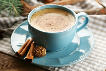 Cup of coffee and Christmas tree branch on napkin, closeup