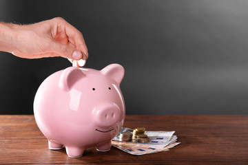 Man putting money in moneybox