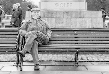 Anziano seduto su una panchina a londra