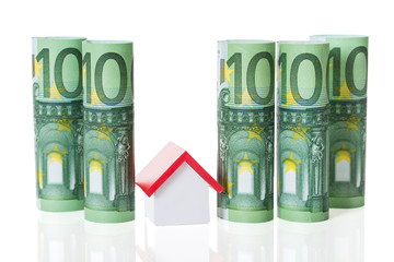 House Model Arranged Amidst Rolled Euro Notes