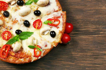 Delicious pizza and fresh vegetables on wooden background, close up