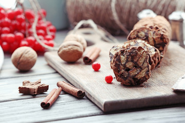Chocolate salami with walnuts and red berries on a table, close up