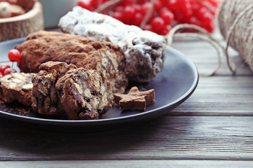 Chocolate salami in a plate on a wooden table, close up