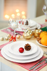 Christmas table setting with holiday decorations on fireplace background
