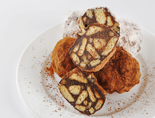 Chocolate salami candies with cocoa powder, close up