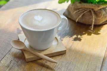 Hot latte coffee in glass  cup mug on wooden table