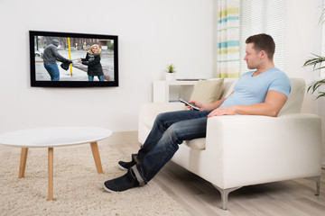 Man With Remote Control Watching Movie In Living Room
