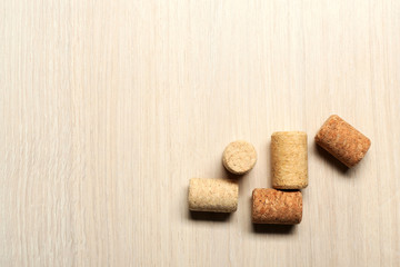 Five wine corks on light wooden background