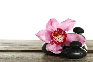 Beautiful pink orchid and spa stones  isolated on white