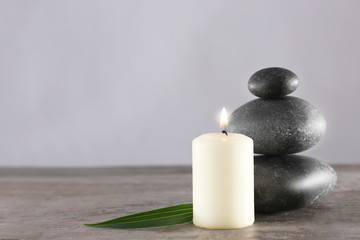 Fototapeta na wymiar Spa stones and candle on grey background