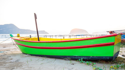 Naklejka na ściany i meble Colorful fishing boat at sand beach with sunrise on the morning.