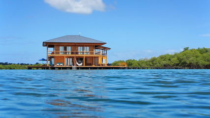 Tropical home over water viewed from sea surface