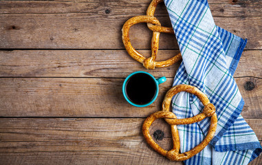Homemade pastries. Pretzel with kitchen towel on wooden background. Food